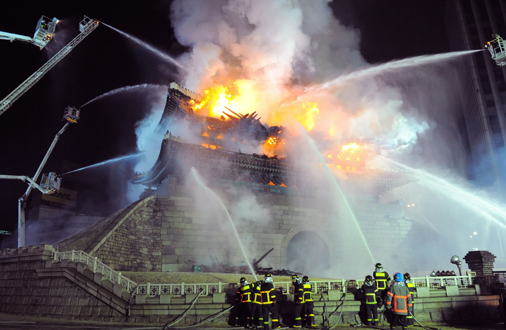 Firefighters battle a blaze at the Namdaemun gate, one of South Korea's most historic sites, in central Seoul, on February 11, 2008. An arsonist started the fire, destroying the gate - the oldest wooden structure in Seoul, first constructed in 1398 and rebuilt in 1447. (Kim Jae-hwan/AFP/Getty Images) #