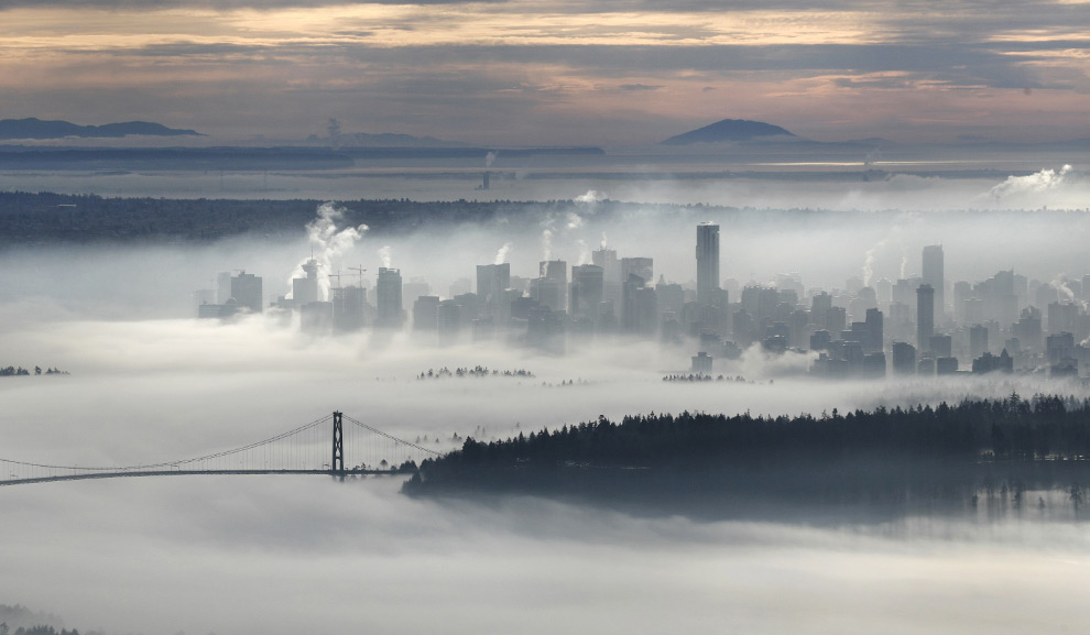 The downtown core of Vancouver and the Lions Gate Bridge rise above a morning fog in this view from Cypress Mountain in West Vancouver, British Columbia November 17, 2008. (REUTERS/Andy Clark) #