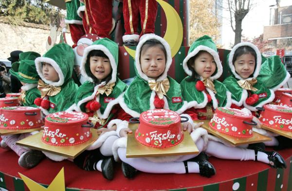  South Korean children wearing Santa Claus outfits hold charity pot-shaped cakes during a ceremony to prepare charity pots for a year-end fund-raising campaign for the underprivileged at the Salvation Army office in Seoul, South Korea, Wednesday, Nov. 26, 2008. (AP Photo/Ahn Young-joon) 