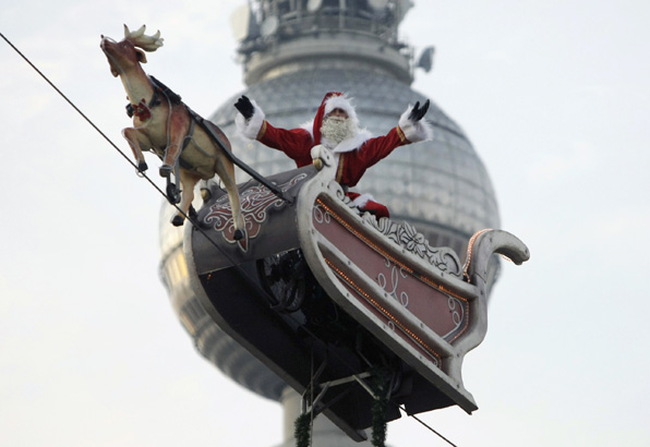  High wire motorcycle artist Dean Schmidt is dressed like a Santa Claus as he waves to visitors of a Christmas fair in Berlin on Monday Nov. 24, 2008. In the background is Berlin's TV tower. (AP Photo/Miguel Villagran) 