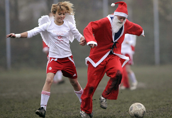  Members of the soccer teams of Angles and Santa Claus challenge for the ball during their charity Christmas soccer match in Hamburg, Germany, on Saturday, Dec. 6, 2008. The charity match between a youth girls team and a 5th division Hamburg men's team is played as a fundraising match for the Uwe Seeler Foundation, and ended in a 10-10 draw. (AP Photo/Fabian Bimmer) 