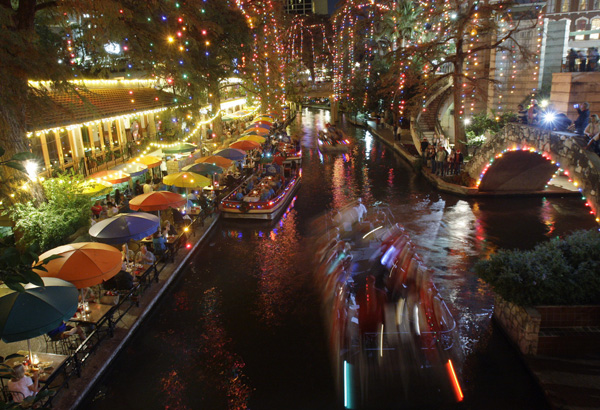  Carolers sing a Christmas song as they ride a barge on the San Antonio River under holiday lights on the Riverwalk in downtown San Antonio, Wednesday, Dec. 3, 2008. (AP Photo/Eric Gay) 