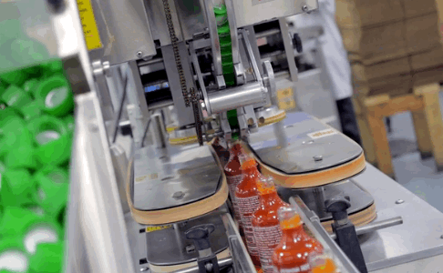 Here, more machines automate the process of reeling in the filled bottles for capping.