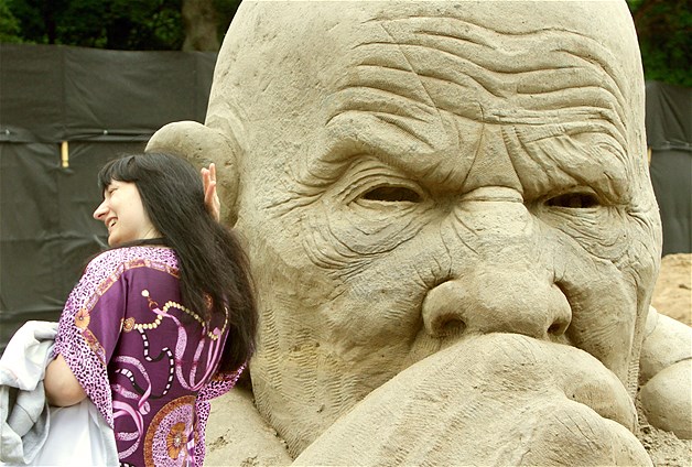 A visitor walks past sand sculptures on display at the International Sand Sculptures Festival in Palanga, Lithuania, July, 14, 2014.