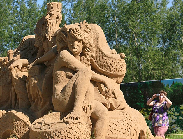A visitor photographs a sand sculpture entitled "Evil Spirits" at the Russian folk fairy tale-themed exhibition of sand sculptures in the Siberian city of Krasnoyarsk, July 21, 2013.