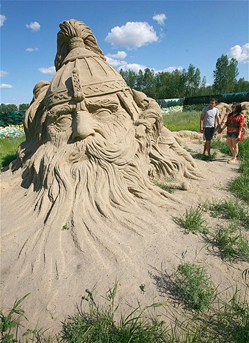 Visitors look at a sand sculpture entitled "Ruslan and Ludmila" at the Russian folk fairy tales-themed exhibition of sand sculptures in the Siberian city of Krasnoyarsk, July 21, 2013.