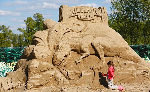 Alina Sitnikova works on a "Jurassic Park" sand sculpture during the preparations for the "My Favorite Film" thematic exhibition of sand sculptures in Russia's Siberian city of Krasnoyarsk, June 6, 2014.