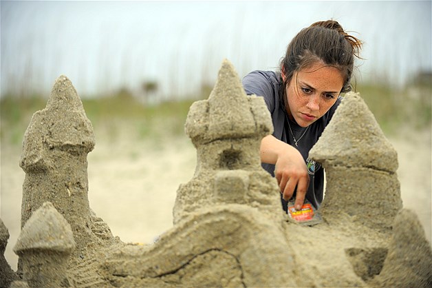 Savannah College of Art and Design alumni Caroline Rose uses a putty knife to carve a turret on top of her sand castle during the 2014 SCAD Sand Arts Festival, May 2, 2014, in Tybee Island, Georgia.