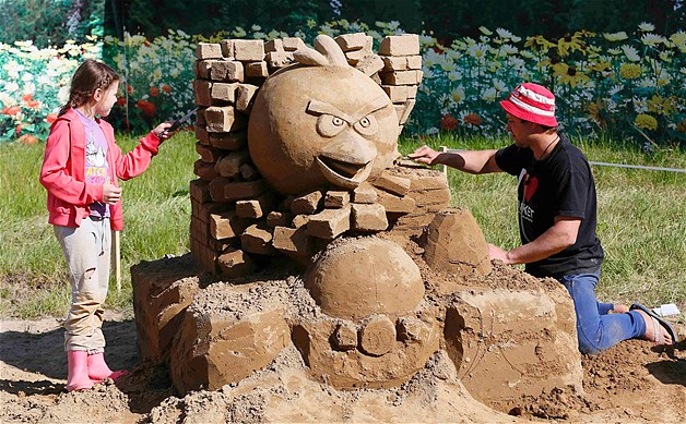 Russian sculptor Alexei Sitnikov and his daughter Alina work on an "Angry Birds" sand sculpture during preparations for the "My Favorite Film" thematic exhibition of sand sculptures in Russia's Siberian city of Krasnoyarsk, June 6, 2014.
