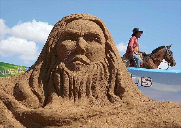 Artist Fernando Terceros rides a horse past the sand sculpture of apostle Simon the Zealot or Simon "El Zelote" during Holy Week celebrations in Arenal de Cochiraya, on the outskirts of Oruro, Bolivia, April 18, 2014. Hundreds of artists and art students gathered for the annual Good Friday event to build sand sculptures based on Biblical stories.