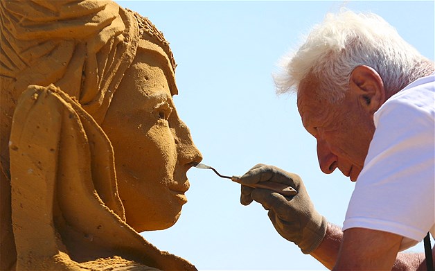 Sand carver Franco Daga of Italy works on a sculpture during the Sand Sculpture Festival in Ostend, Belgium, June 23, 2014.