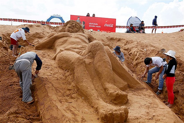 Artists from Cuzco, Peru, shape a sand sculpture depicting Jesus Christ during Holy Week celebrations in Arenal de Cochiraya, on the outskirts of Oruro, Bolivia, April 18, 2014. Hundreds of artists and art students gathered for the annual Good Friday event, building sand sculptures based on Biblical stories.