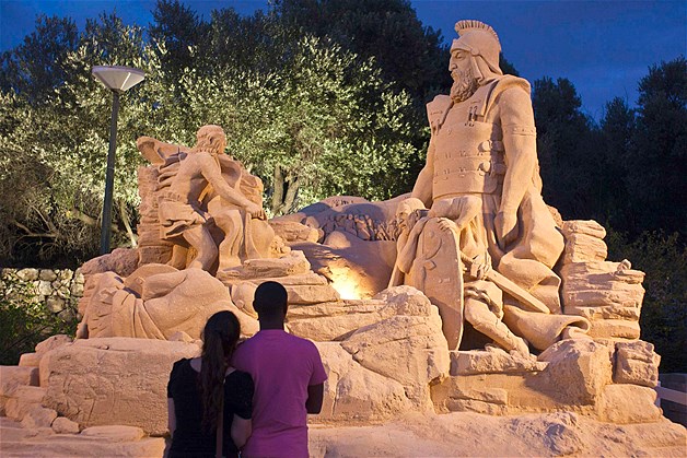 A couple gazes at a sand sculpture depicting "David and Goliath" at an exhibition in Tel Aviv, Israel, July 2, 2013. The sculptures depicting characters from children's stories and from the Bible were designed by Israeli and Dutch artists.