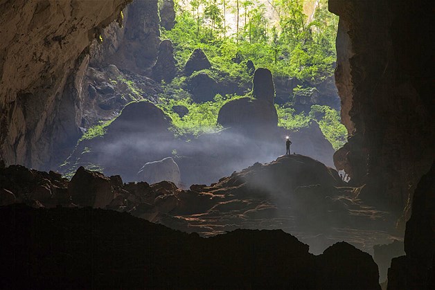 A caver stands outside one of the entrance of the Hang Son Doong cave in Quang Binh Province, Vietnam.