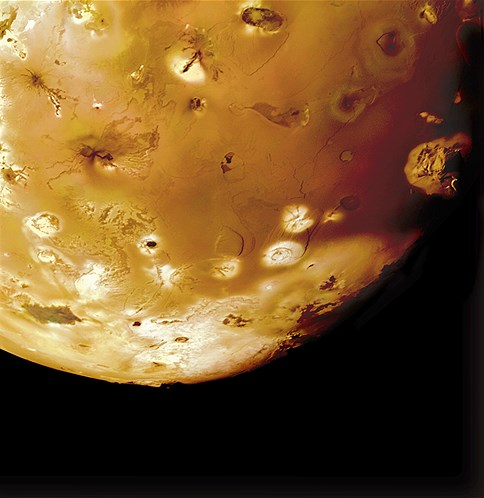 Volcanoes, lava flows and mountains on Jupiter's moon Io. Haemus Mons, a 32,000-foot mountain, is entering the moon's night side on the right.