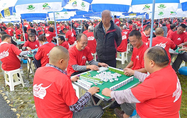 People play mahjong during their attempt to break the Guinness World Record of the most number of people playing mahjong simultaneously in Dujiangyan, Chengdu, Sichuan province, China, Sept. 19, 2013. Around 2380 people broke the record after playing mahjong simultaneously.
