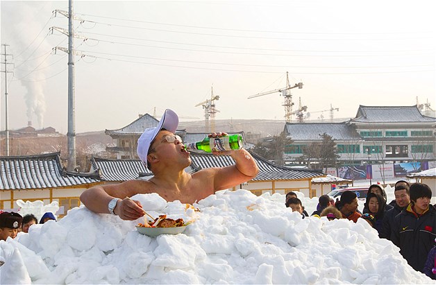 Jin Songhao drinks beer as he sits in snow during a cold endurance performance in Yanji, Jilin province, China, Jan. 12, 2013. Jin set the Guinness World Record for the longest time spent in direct full body contact with snow on Jan. 17, 2011, with a time of 46 minutes and seven seconds.