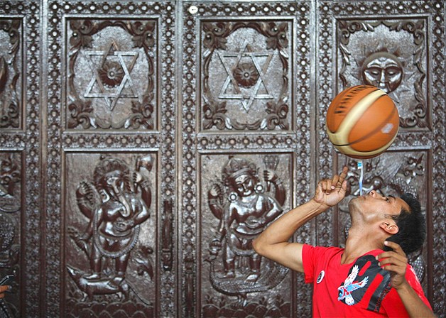 Thaneshwar Guragai spins a basketball on a toothbrush while holding the toothbrush in his mouth for exactly 22.41 seconds to break the last Guinness record of 13.5 seconds set by Thomas Connors of U.K., in Kathmandu, Nepal, April 19, 2012.