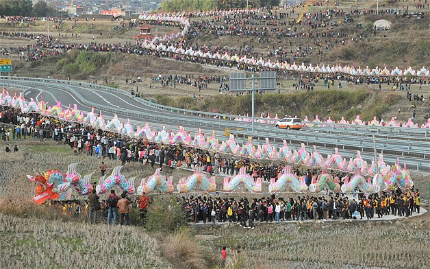 Villagers perform the annual "dragon march" to celebrate the Lantern Festival in Gutian township, Fujian province, China, Feb. 6, 2012. The traditional march, usually performed during Lantern Festival, has a history of more than 200 years. The marching dragon, made of paper and bamboo and connected by wood planks, set the new Guinness World Record of the longest parade float, with 2596 feet.