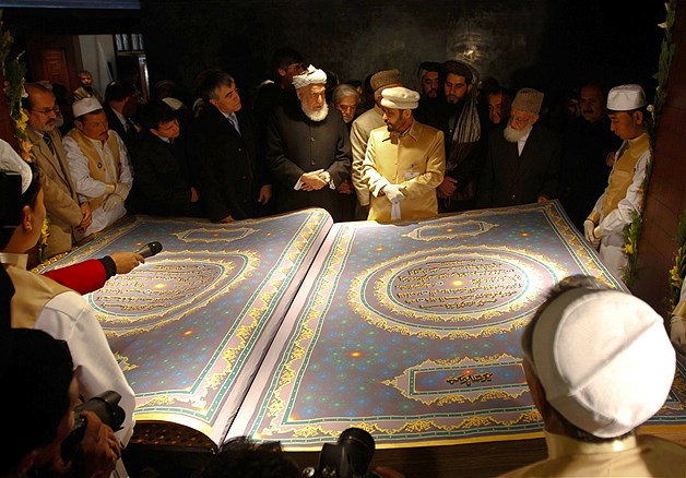 Calligrapher Mohammad Sabir Khedri center right gives information about the biggest Koran in the world to Afghan officials during its inauguration ceremony in the Hakim Nasir Khosrow Balkhi library in Kabul, Jan. 12, 2012. The Afghan calligrapher has worked for five years to create the world's biggest Koran, a bid to show the world that Afghanistan's rich cultural heritage and traditions have been damaged but not destroyed by 30 years of war.