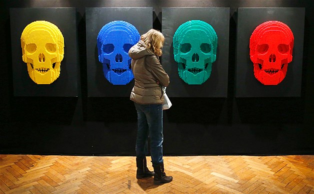 A visitor looks at the art work titled "Skulls," which is constructed out of 12,444 Lego bricks, during the "The Art of the Brick" exhibition at the Brussels Stock Exchange, Nov. 25, 2013. The exhibition featured large Lego art works by New York Lego artist Nathan Sawaya.