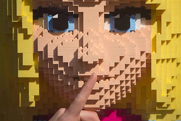 Shhhh! A consumer touches the mouth of Lego Friends sculpture "Stephanie" at Toy Fair 2013 in New York, Feb. 11, 2013.