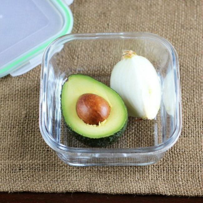 Store cut avocado with cut onion. Sulfur from the onion keeps the brown away. A light sprinkle of apple cider vinegar also works.