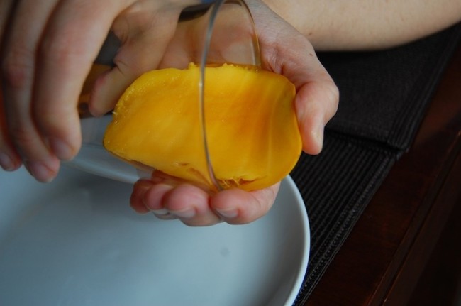Peel mangoes with a glass. Avoid sticky fingers and leave no mango behind.