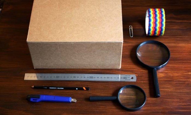 You'll need a cardboard box, duct tape, a magnifying glass (two pictured, but you only need one), a paper clip, an X-Acto or Stanley knife, and your smartphone.