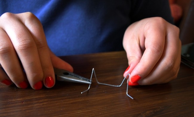 Use a pair of pliers to form a stand for your phone from a paperclip.