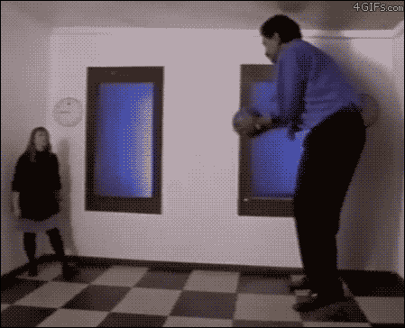 The "Ames Room" illusion messes with our depth perception and is created by slanting the back wall of the room towards the camera and the ceiling downwards.