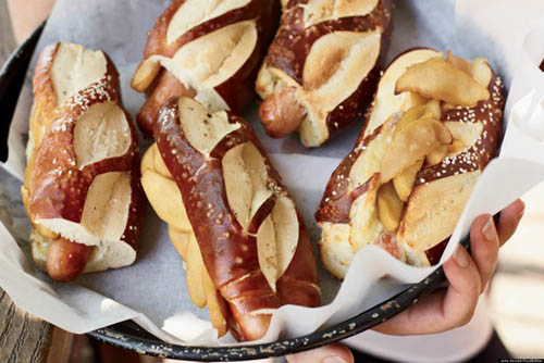 Hot Dogs with Cheddar and SautÃ©ed Apples: Combination of cinnamon sautÃ©ed apples with slices of sharp cheddar cheese, served on top of hot dogs tucked into pretzel rolls.