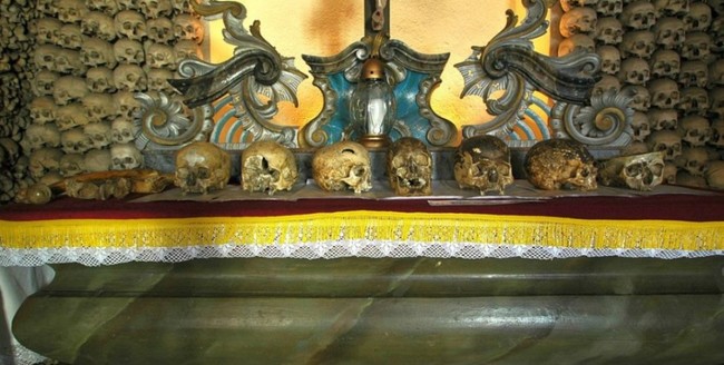 What was the point of this gruesome project? The church was intended to be a shrine for the dead, and the display of the skulls was meant as an honor to the people who perished from violence and disease. It was also meant to serve as a "memento mori" for the living, reminding them that they, too, would one day die. That doesn't mean that Tomaszek was immune to being interested in the weirder aspects of an already weird project. The altar, seen here, is reserved for the more curious specimens. These skulls include a few deformed by syphilis, the skull of a local mayor, several skulls punctured by bullet holes, and the skull of an alleged giant. Tomaszek's skull joined the crowd when he died in 1804.