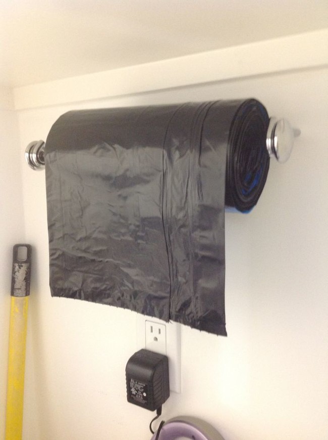 Use a paper towel holder to store large garbage bag rolls.