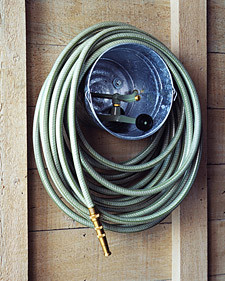 Use an old bucket as a way to wrap up a hose and store it on your wall.