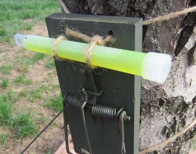 Set up a glow-in-the-dark security system for your campsite with a mousetrap and a glow stick.