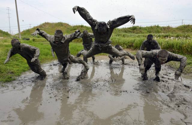 In mainland China, paramilitary policeman face an intense regimen. Here, the policemen take part in a training session in muddy water.
