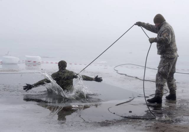 A Canadian soldier in Latvia takes part in ice-plunge training as part of NATO exercise Operation Atlantic Resolve.