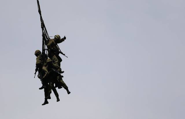 Over in Japan, members of the Ground Self-Defense Forces practice holding onto a rope dangling from a cargo helicopter.