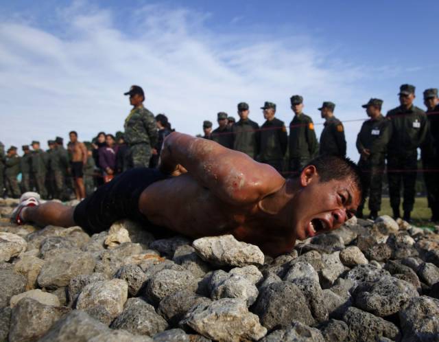 In Taiwan, in order to pass the final stage of a nine-week Amphibious Training Program, a trainee crawls along a 150-foot path of jagged coral and rocks on his belly.