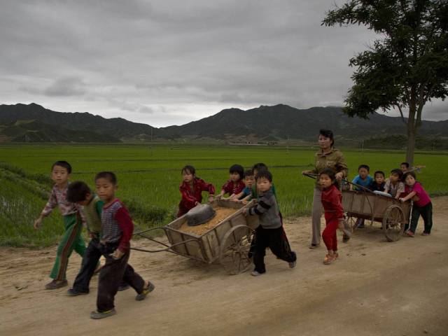 Young North Korean schoolchildren help to fix pot holes in a rural road in North Korea’s North Hamgyong province