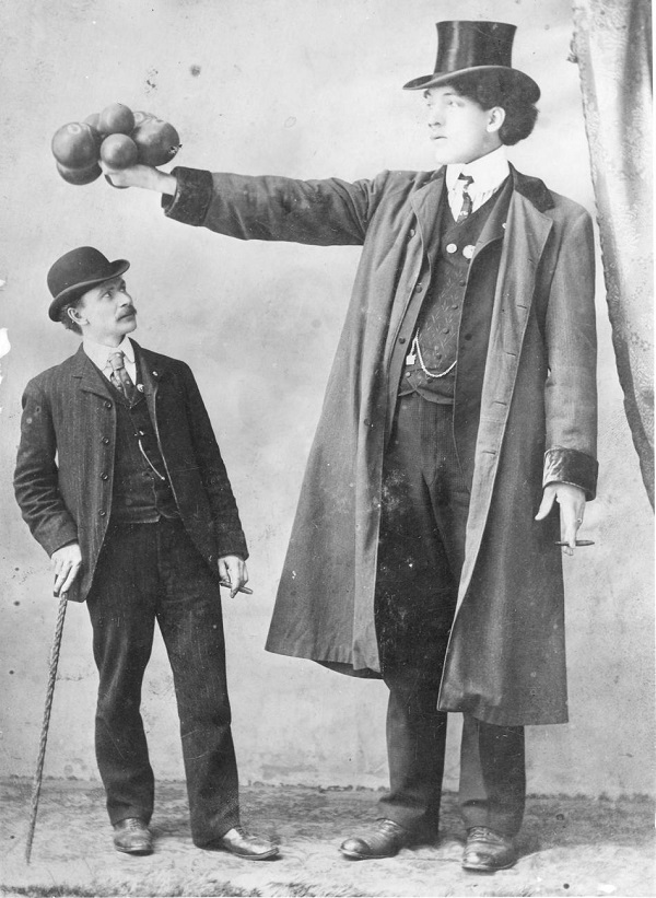 Edouard Beaupré was the first of 20 children born to Gaspard & Florestine Beaupré. At the time of his death, he was one of the five tallest men in the world due to his 8' 3" frame. He died at the age of 23 from a pulmonary hemorrhage during a show at the Louisiana Purchase Exposition in St Louis.

Beaupré's cause of death is fairly common, but the events that took place after his death are truly disturbing. His corpse was sent to funeral directors Eberle and Keyes to be embalmed and prepared for interment. The remains were to be then returned to Willow Bunch, Saskatchewan by William Burke, the circus manager, but he balked at the effort and shipping costs required. Burke instead convinced the Beaupré family to bury Edouard honorably in St. Louis—in order to spare everyone the expenses involved. The family agreed and believed that the funeral took place, but instead Burke simply skipped town and left the cadaver unclaimed and the funeral director unpaid.

To make up for the financial loss, the funeral home put Edouard's lifeless body on display in a storefront window with hopes of making a profit. The body caused so much pedestrian traffic that the municipal authorities eventually demanded that it be removed.

Beaupré's body would be sold two more times, and on one occasion, it was put on display at the Eden Museum of Quebec. In 1907, his corpse was found in a shed in Montreal, stored there after a circus that had purchased it had gone bankrupt. 

Beaupre's body then fell into the hands of a respectable doctor by the name of Louis Napoléon Delorme at the University of Montreal. While his title may have been respectable, his demeanor wasn't. He mummified Edouard and placed him on display for the Faculty of Medicine. Edouard remained there for 85 years. 

In 1975, Edouard Beaupre's nephew, Ovila Lespérance, petitioned the university to release the remains to his descendants. In 1989, the university finally agreed to cremate the remains and on July 7, 1990, the "Willow Bunch Giant" was finally buried with the dignity that he deserved. A life-sized statue was created in honor and celebration of his life.