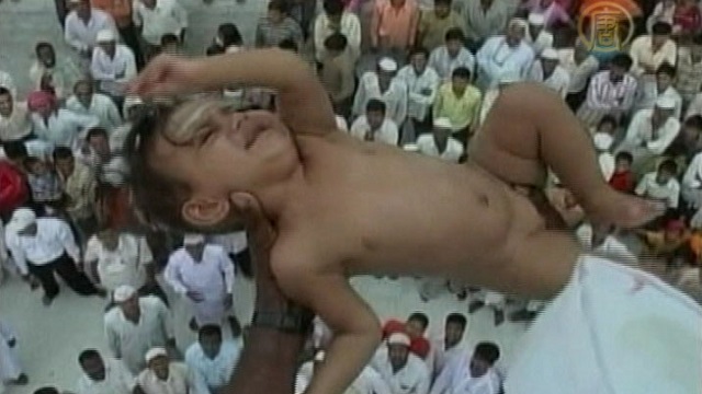 In a local practice believed to bring prosperity and wealth to the families, babies are dropped about 50 feet from the top of a building to a sheet firmly held by men below. Near Sholapur, India, the ritual has been practiced for almost 700 years, and both Muslims and Hindus participate.