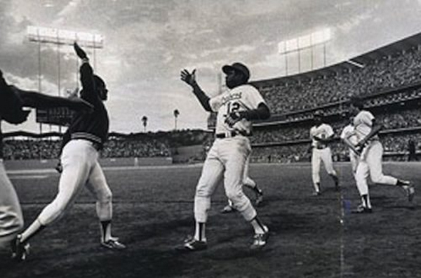 Everyone from sports figures to politicians have performed at least one high five. But this now ubiquitous salutation can be traced back to one particular baseball game. It was October 2, 1977 in Los Angeles at the last game of the season between the Astros and Dodgers. Dodger Dusty Baker slammed a 3-run homer to tie the score. When Glenn Burke, on deck, thrust his hand in the air, Baker instinctively smacked it. Burke stepped up to the plate and also hit a homer. On the way back, Burke returned Baker's slap, ushering in the era of the High Five.