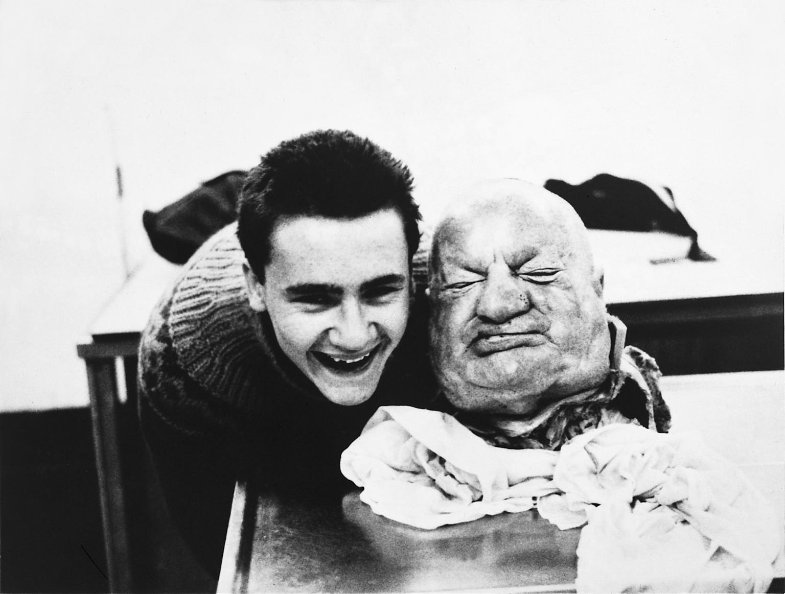 “With Dead Head” British artist Damien Hirst poses with a severed head in a morgue in 1981.