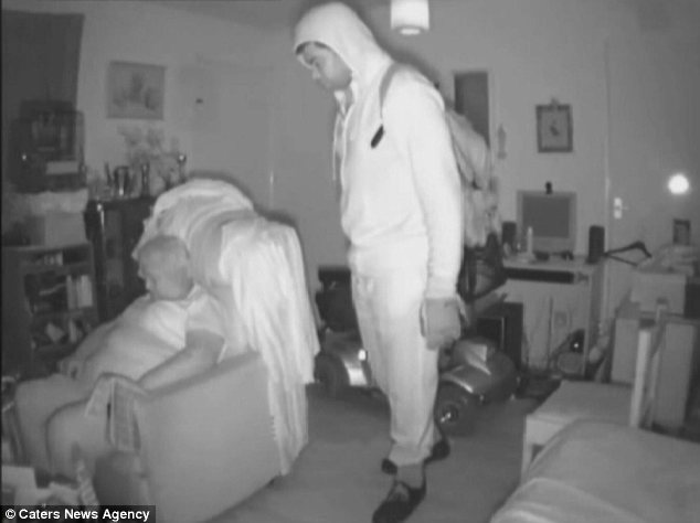 Home intruder stares at sleeping resident