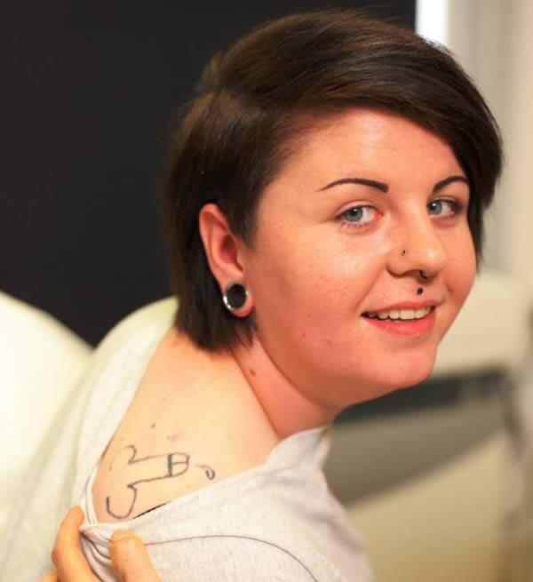 A former wild child has spoken of her horror of living with the most embarrassing tattoo in Britain—a penis on her shoulder. 

Holly Aston, 20, woke up after a drunken party to discover the obscenity inked on her body. And the student says it has ruined her life.

Aston hid the tattoo from her parents for two years until the awful truth came out in 2014. She was just 17 when she allowed drunk friends to draw the penis on her shoulder with a DIY tattoo gun she had bought on the internet and later woke up horrified by the graphic image permanently etched on her body.