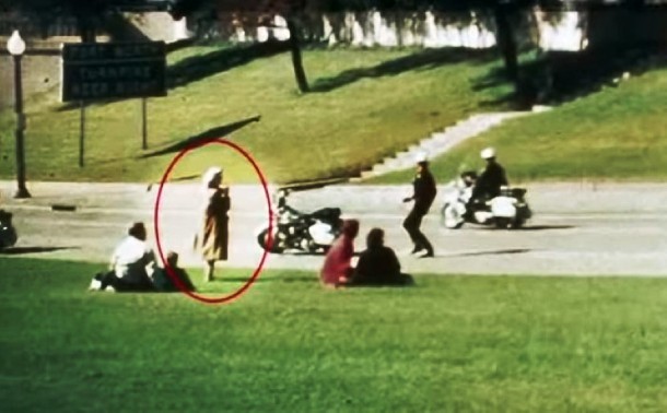 The Babushka Lady is a nickname for an unknown woman present during the 1963 assassination of President John F. Kennedy. As she was seen to be holding a camera, she might have photographed the events during the assassination. Even though the shooting had already taken place and most of her surrounding witnesses took cover, she can be seen still standing with the camera at her face. Neither she, nor the film she may have taken, has yet been positively identified.