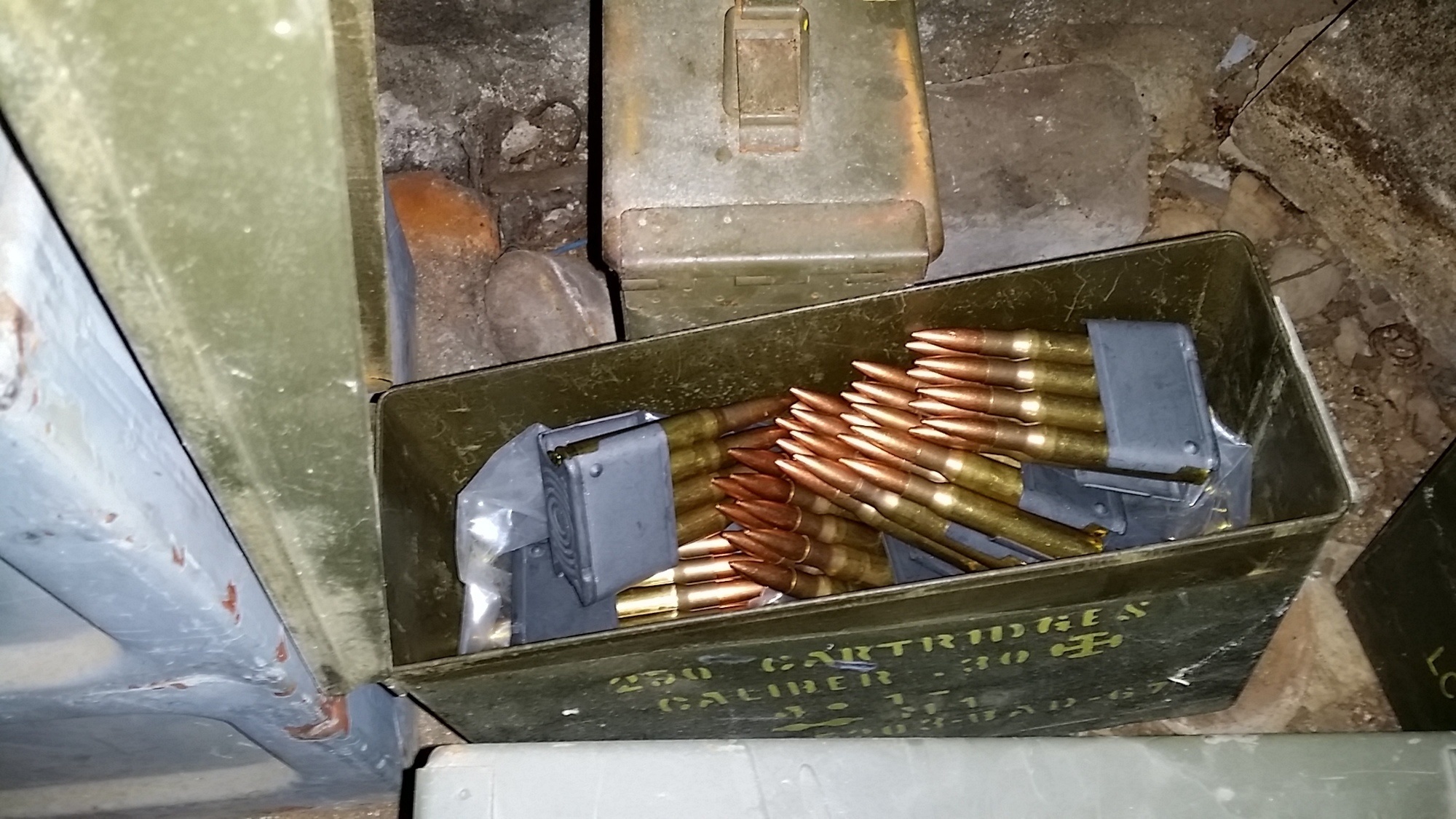 In a secret room of one person's home, a box with ammunition, a defused grenade, and thousands of pennies.