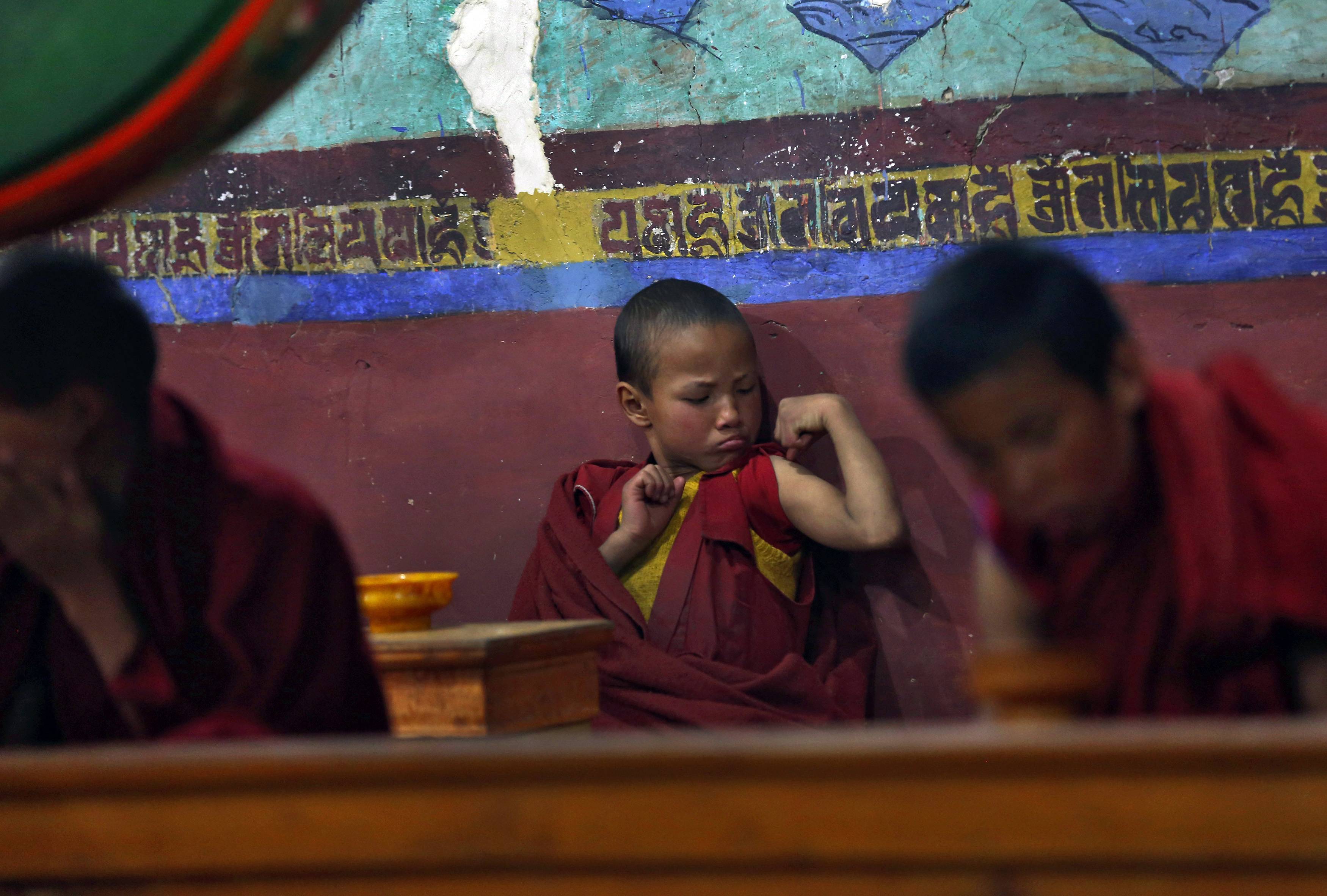 A young Buddhist monk during morning prayers at the Thikse Monastery in Ladakh, India